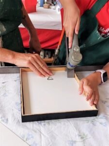With a point driver, I inserted framing points — the small metal tabs that keep the artwork secure inside the frame.